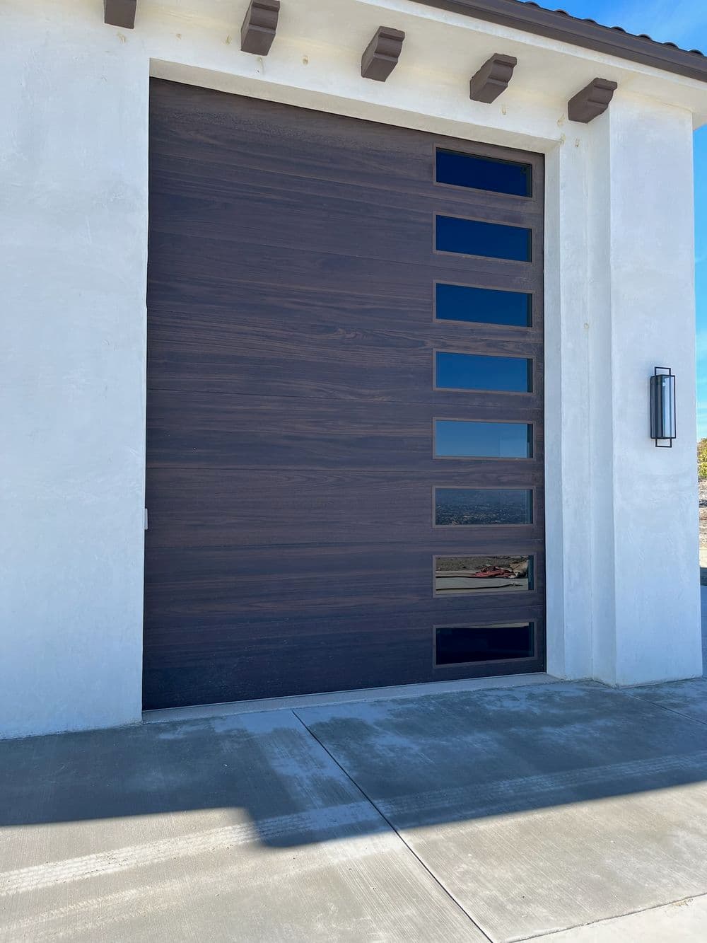 Modern wooden garage door with horizontal panels and a sleek design on a contemporary home.